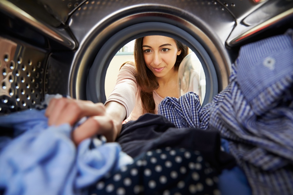 woman looking into a washing machine 
