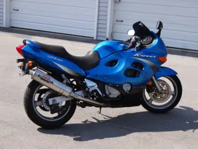 2002 Suzuki Katana 600 motorcycle sits outside near storage garages